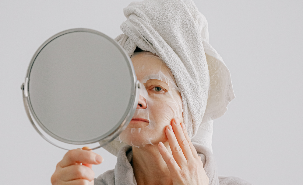 woman have a face masks on looking at the mirror